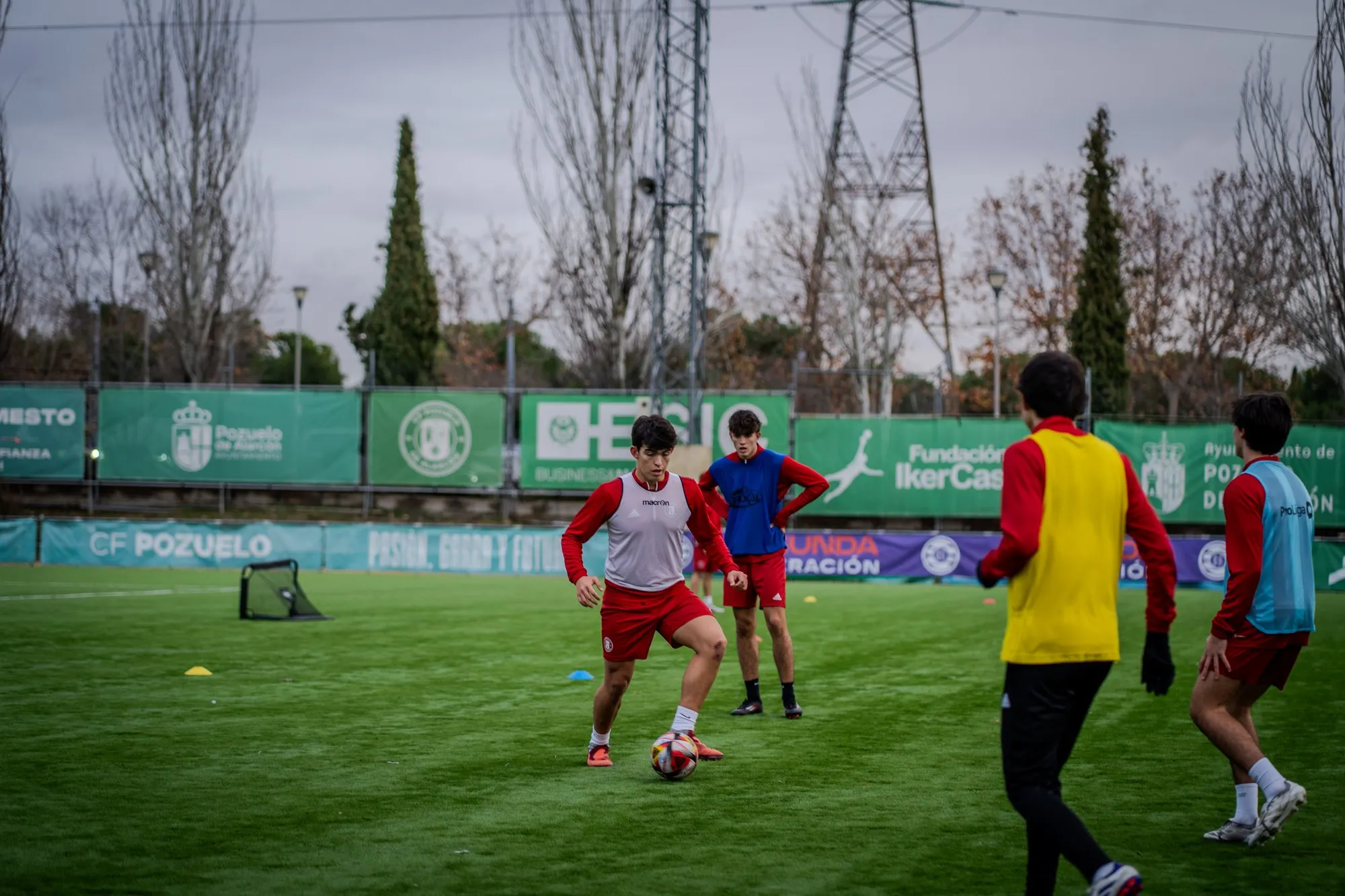Jugadores disputando el balón durante un partido en el campo del campus