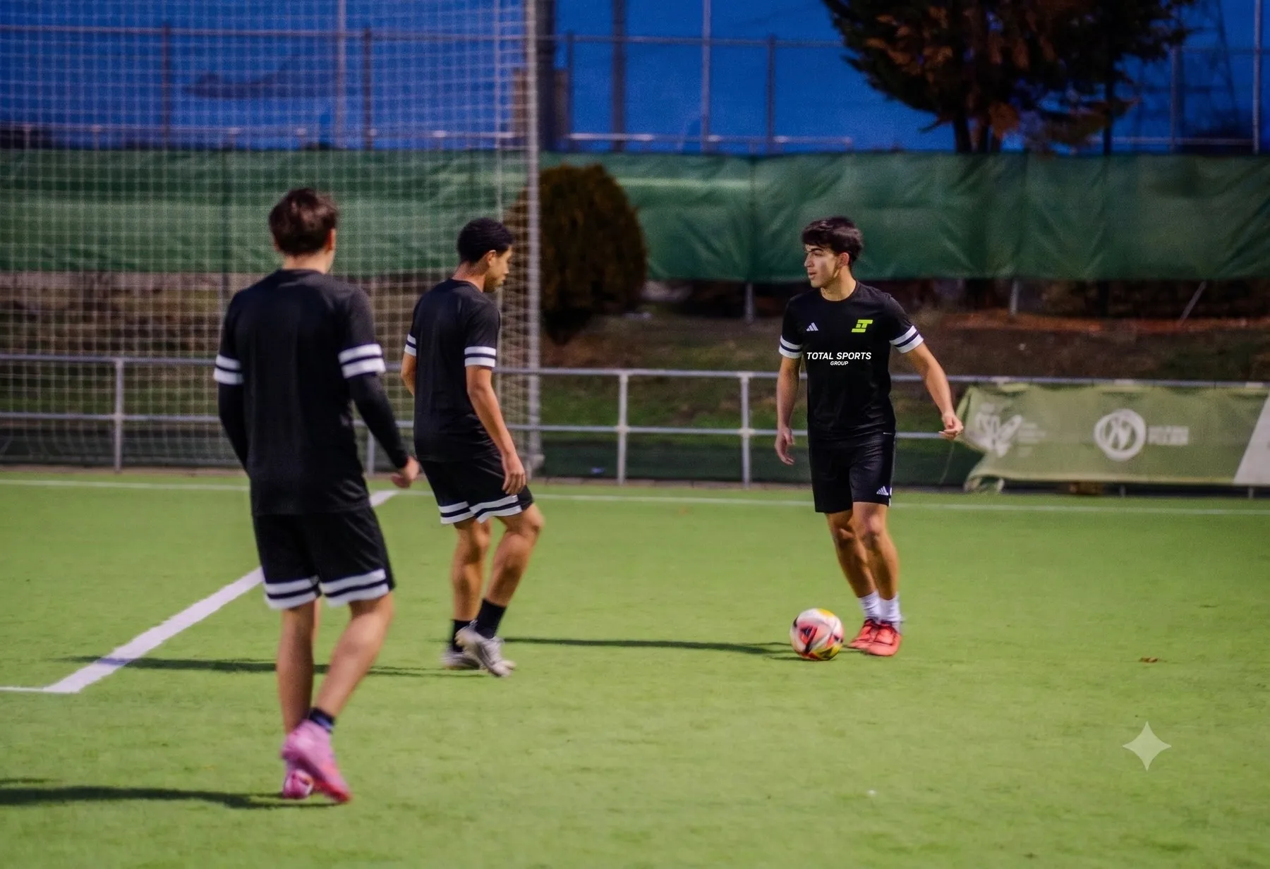 Jugadores trabajando con el balón en un entrenamiento al atardecer
